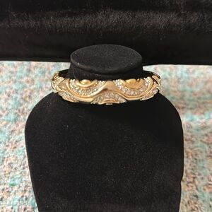 Gold tone jeweled wave detailed bangle bracelet